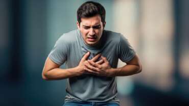 young adults dying of heart attack concept where a young man clutching his chest in pain possibly experiencing a heart attack or other serious medical emergency