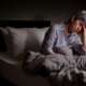 A depressed senior woman sitting in bed cannot sleep from insomnia