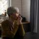 Lonely old woman in kitchen suffering from dementia