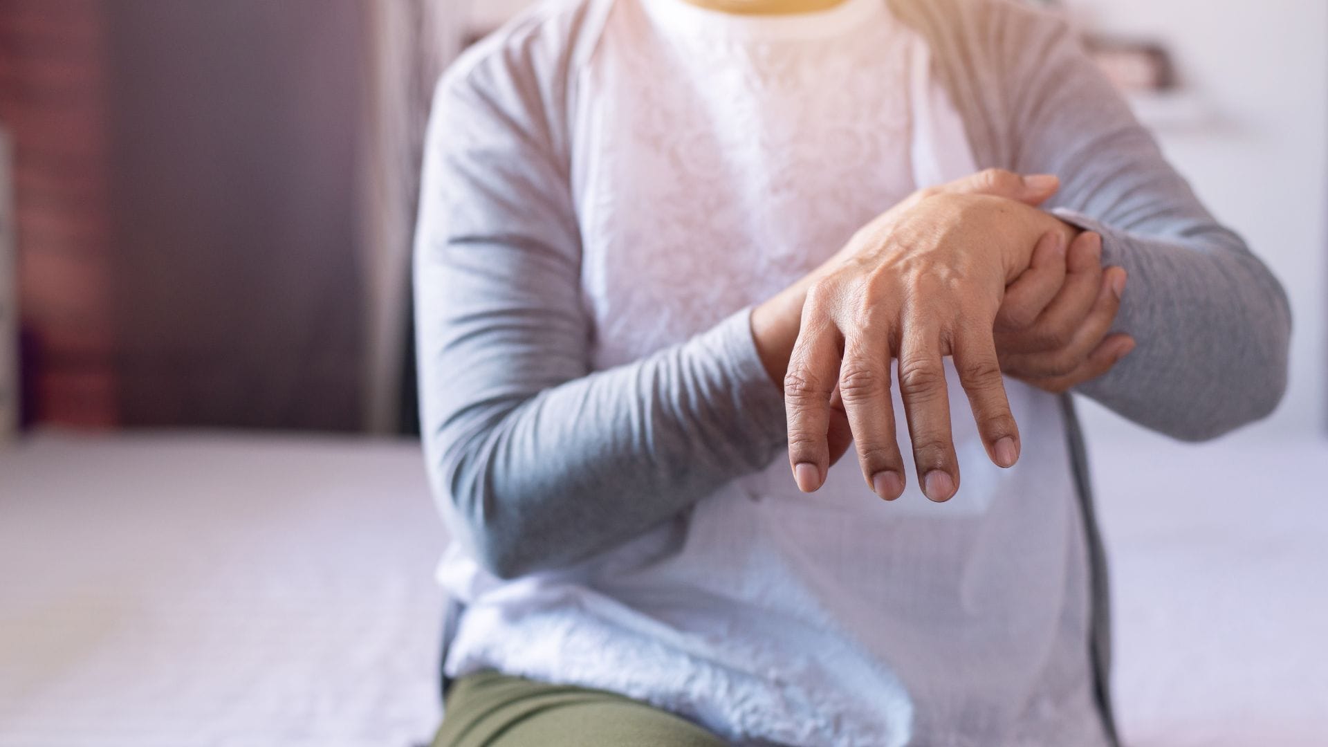 Close-up hands of senior elderly woman patient suffering from Parkinson's disease symptoms