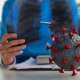 A specialist is looking at the x-ray with artificial virus model on table representing acute respiratory distress syndrome