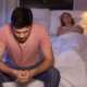 A sad man with erectile dysfunction sitting on bed at night