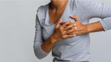 Young woman examining her breast lumps with her hand