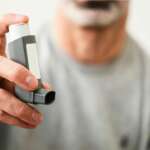 man holding asthma inhaler close up shot