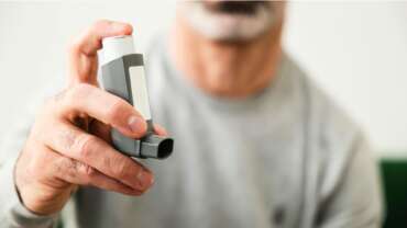man holding asthma inhaler close up shot