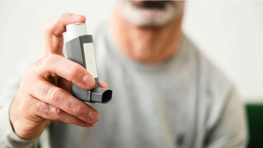 man holding asthma inhaler close up shot