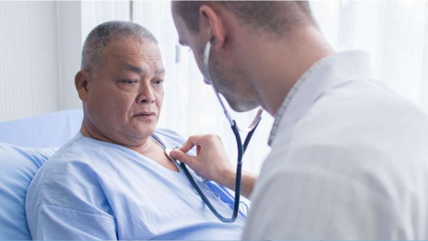 male doctor hold a stethoscope and listen to mature male patient's heartbeat in private clinic who is suffering from reverse coronary artery disease