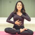 A woman in a yoga pose performing gut health exercise