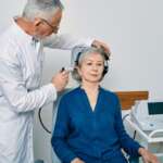 Senior physician man with otoscope test for causes of hearing loss