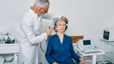 Senior physician man with otoscope test for causes of hearing loss