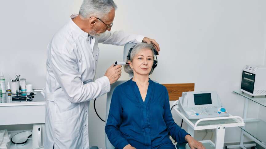 Senior physician man with otoscope test for causes of hearing loss