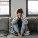 woman with a headache, stress, burnout, anxiety, tiredness, or thinking in house representing chronic fatigue syndrome