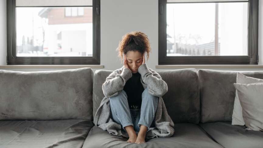 woman with a headache, stress, burnout, anxiety, tiredness, or thinking in house representing chronic fatigue syndrome