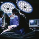 Serious surgeons during a surgery in the hospital representing complications of cabg surgery
