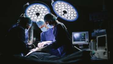 Serious surgeons during a surgery in the hospital representing complications of cabg surgery
