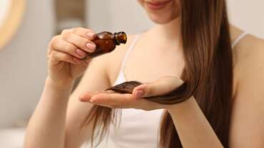 A woman applying hair oil for hair growth