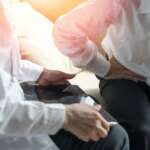 a man feeling pain on his tummy area and consulting a doctor representing difference between ulcerative colitis and Crohn's disease