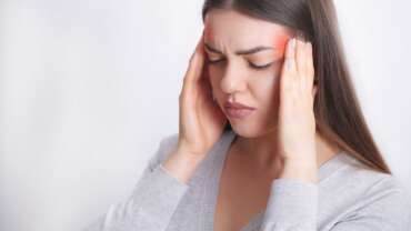 A hardworking woman suffer huge migraine, feeling pain in head representing phases of migraine headache