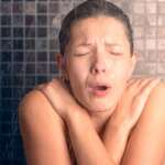 woman screaming in the shower under cold water jet, representing the benefits of cold shower