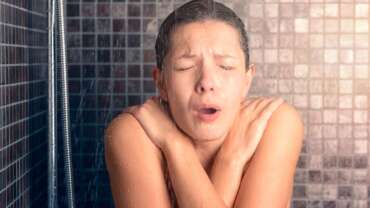 woman screaming in the shower under cold water jet, representing the benefits of cold shower