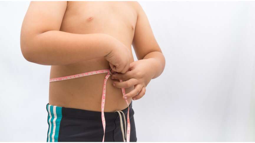 A boy holding measuring tape, representing effects of child obesity