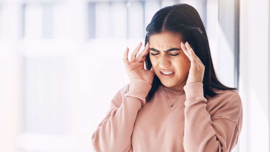 a frustrated young female struggling with a migraine