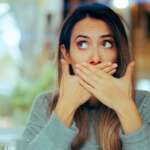 Young woman suffering from burping in middle of the street
