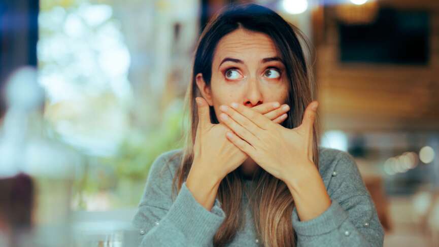 Young woman suffering from burping in middle of the street