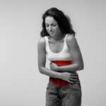 Young woman suffering from abdominal pain due to heavy menstrual bleeding