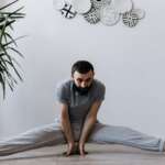 a man stretching his legs and balancing through his hands, performing exercise for healthy prostate