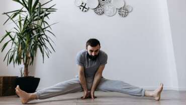 a man stretching his legs and balancing through his hands, performing exercise for healthy prostate