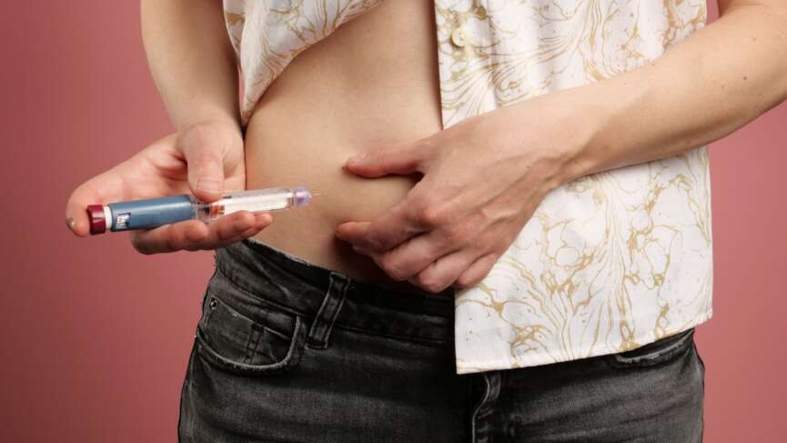 A woman with diabetes making insulin injection into her belly at home for the medications for type 1 diabetes