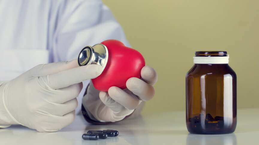 a doctor with a stethoscope and plastic heart with medications aside, trying to present the benefits and potential side effects of entresto