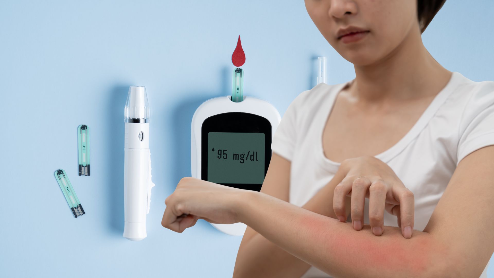 A woman looking at her skin, which can be a sign of diabetes and high diabetes result in glucometer in the background