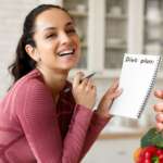 a beautiful women planning her meal strategies for diabetes control and a glucometer device on the side