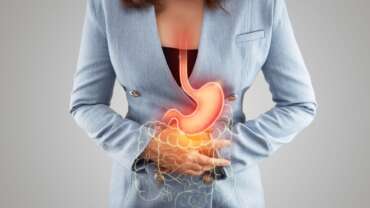 A woman holding stomach in pain from gastritis seeking natural remedies