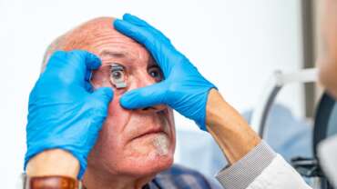 Ophthalmologist applying an eye opener on a senior patient for glacoma checkup and treatment