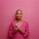 Bald female with breast cancer awareness ribbon