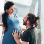 Happy young married family couple outdoor in nature have fun and waiting baby and representing young family growth and pregnancy concept