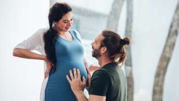 Happy young married family couple outdoor in nature have fun and waiting baby and representing young family growth and pregnancy concept