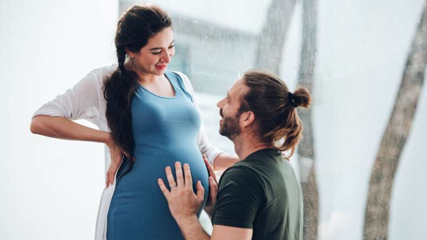 Happy young married family couple outdoor in nature have fun and waiting baby and representing young family growth and pregnancy concept