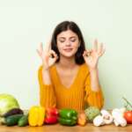 Happy girl with various healthy fruits in home kitchen. Reduce inflammation fast concept