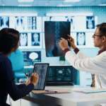 A CT scan radiologist showing an X-ray to girl in computed scanning room. CT Scan and PET Scan concept