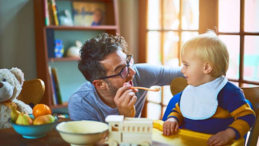 Dad feeding his child with a spoon. diet plan for child concept