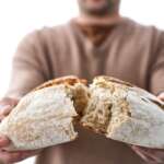Young woman holding freshly homemade rustic bread. freezing bread for weight loss concept