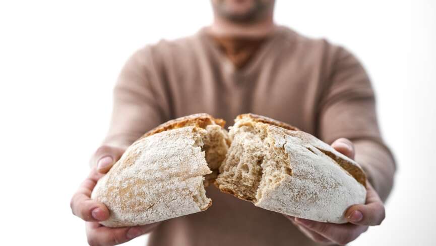 Young woman holding freshly homemade rustic bread. freezing bread for weight loss concept
