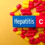 Top view of a medical pill and colored cube with the word "Hepatitis C" medical concept