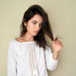 A woman hands holding dry, damaged hair ends. How to find hair porosity concept
