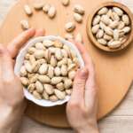 pistachios health benefits concept where a girl holding a bowl full of pistachios