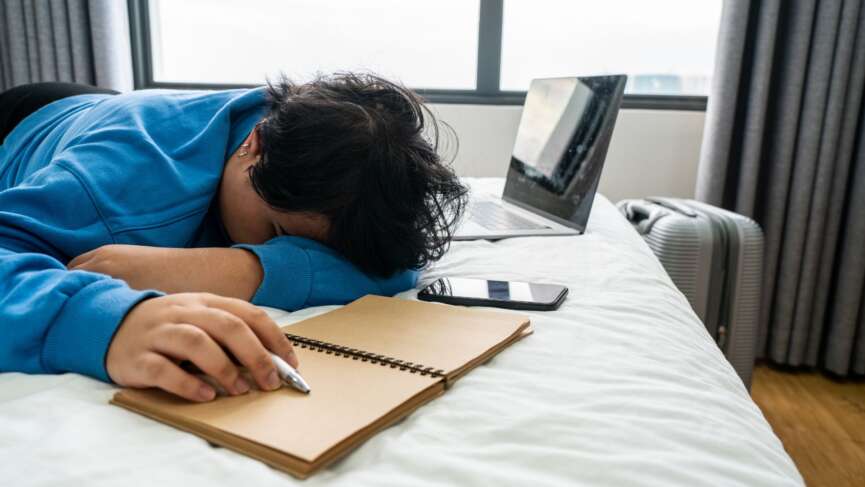 Women with a notebook and laptop and tired with deadline depression, fatigue, exhaustion, representing narcolepsy in adults